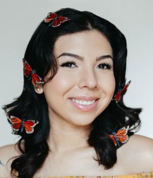 person with dark hair and red butterflie woven into their hair