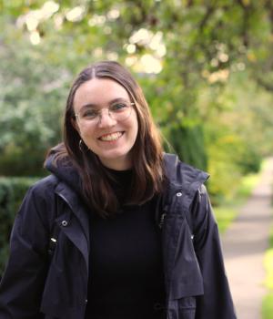 Person wearing glasses smiling outside