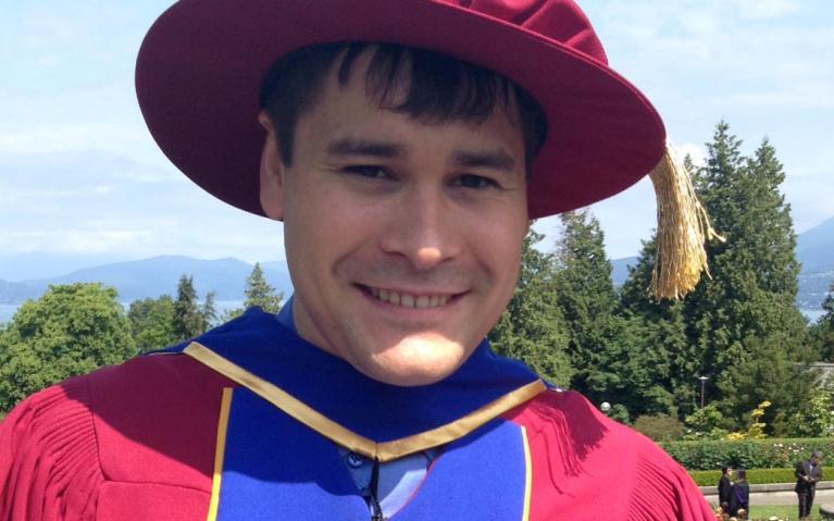 Dustin King, in his acedemic robes, shows off his Governor General's Gold Medal