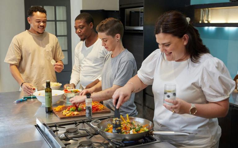 Group of people in a kitchen eating together