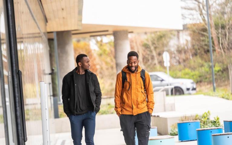 two men walking outside housing building