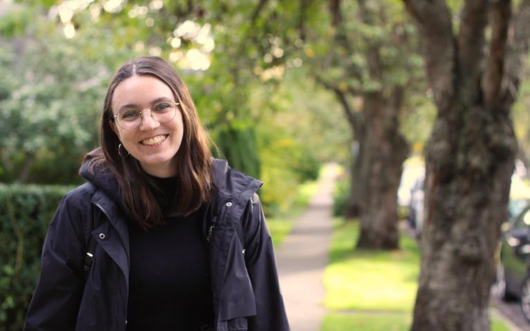 Person wearing glasses smiling outside