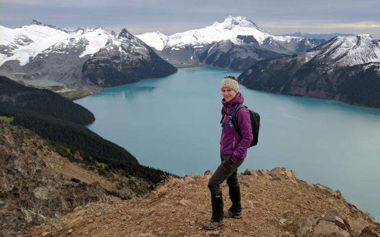 Lucy Rodina stands atop a mountain