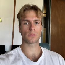 Person wearing a white tshirt standing in front of a wall