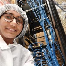 SuperCDMS SNOLAB Data Acquisition hardware testing at TRIUMF: This is me in front of the hardware setup for testing at TRIUMF. The setup is inside a clean room meaning that we must have proper coats, head covering and even a beard covering for those folks with a beard. We also wear boot covers after which we walk on a sticker mat to get any dirt off the covers. This is me in full gear inside the clean room.