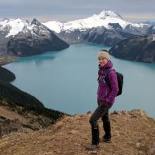 Lucy Rodina stands atop a mountain