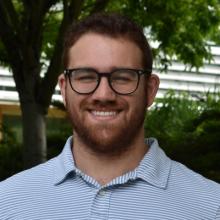 Main with glasses and a beard standing outside